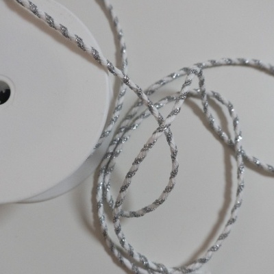 Rolo de fita branca com fio prateado trançado sobre fundo branco