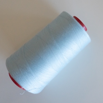 Carretel de linha de costura azul claro com extremidades vermelhas