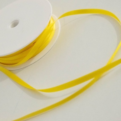 Rolo de fita fina amarela em carretel branco