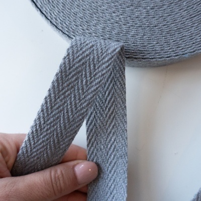 Fita têxtil cinza padrão espinha de peixe enrolada em carretel