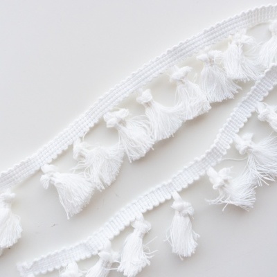 Franja decorativa branca com tufos de fios pendurados