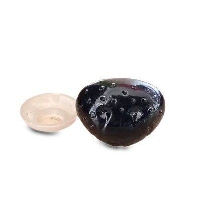 Duas peças de vidro oval, uma branca translúcida lisa e outra preta com bolhas no interior