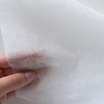 Tecido branco translúcido com textura leve e fina segurado por uma mão