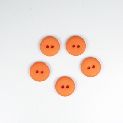 Cinco botões redondos laranja com dois orifícios sobre fundo branco
