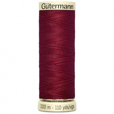 Rolo de linha de costura cor vinho da marca Gütermann com indicação 100 m -110 yds/vgs