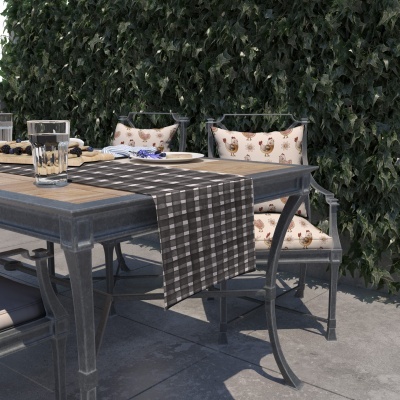 Mesa de exterior com tampo de madeira, toalha xadrez, cadeiras com almofadas estampadas, copos e pratos ao ar livre