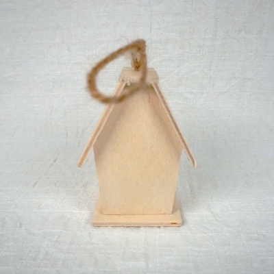 Casa decorativa em madeira clara com cordão de sisal sobre superfície branca texturizada