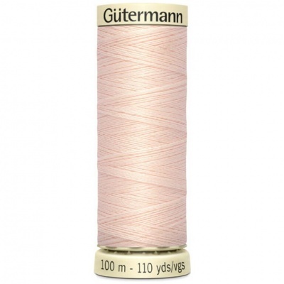 Spool of pale pink sewing thread with Gütermann label