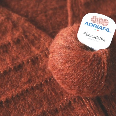 Novelo de fio felpudo castanho avermelhado com etiqueta ADRIAFIL Abracadabra