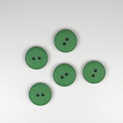 Botões verdes redondos com dois furos sobre fundo branco