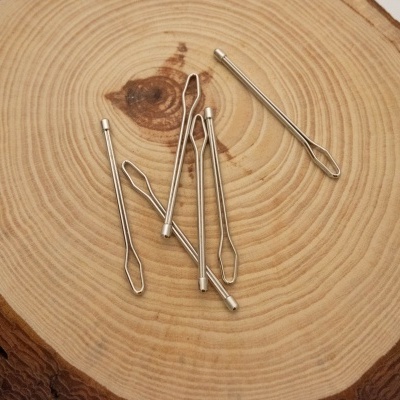 Agulhas de metal prateadas sobre madeira com textura natural
