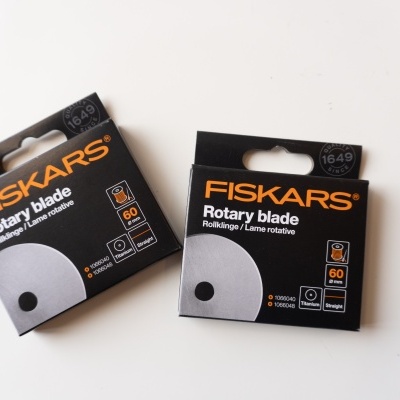 Duas caixas pretas de lâminas rotativas FISKARS sobre superfície branca