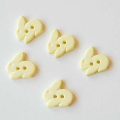 Botões amarelos em forma de coelho sobre fundo branco