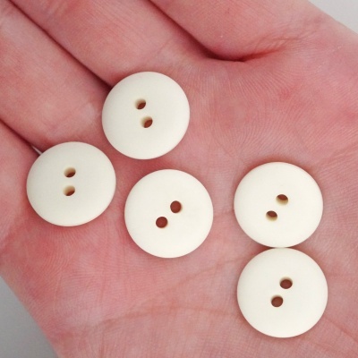 Cinco botões brancos redondos na palma da mão