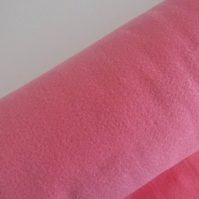 Tecido felpudo rosa com textura macia e ligeiramente enrugada