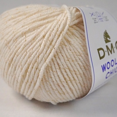 Novelo de lã creme com fios dourados e etiqueta DMC Wool Chic