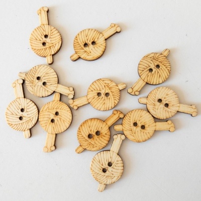 Doze botões redondos de madeira clara com padrão radiante e dois furos numa superfície branca