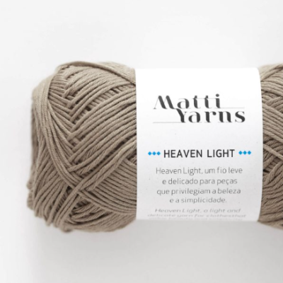 Novelo de fio bege Matti Yarns Heaven Light com rótulo branco sobre fundo branco