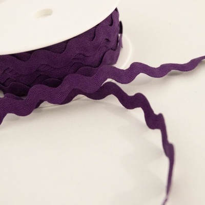 Rolo de fita de tecido roxa ondulada num carretel branco