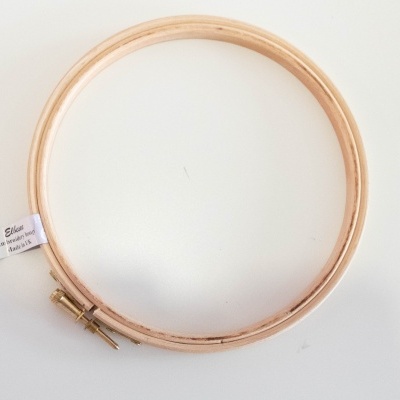 Aros de bordado em madeira clara com etiqueta e fundo branco