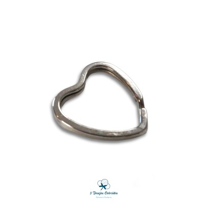 Anilha metálica em forma de coração prateado sobre fundo branco com logotipo azul