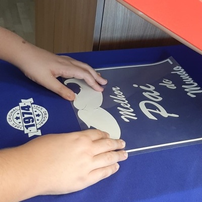 T-shirt azul com estampa branca e prensa térmica vermelha numa mesa de madeira