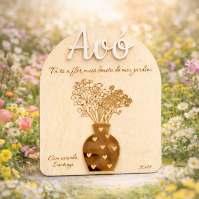 Placa decorativa de madeira com mensagem para avó e vaso estampado, rodeada por flores ao ar livre