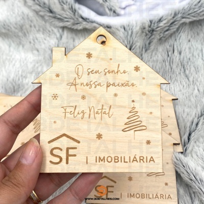 Enfeite de madeira em forma de casa com texto e logo SF Imobiliária