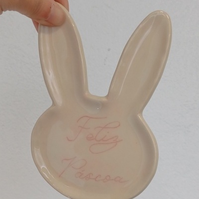 Prato em cerâmica formato cabeça de coelho com texto Feliz Páscoa
