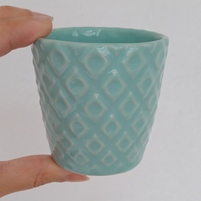 Vaso pequeno azul esverdeado com padrão geométrico em relevo