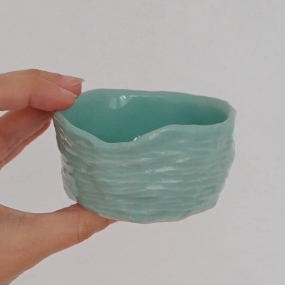 Pequeno recipiente azul-turquesa de cerâmica com textura ondulada