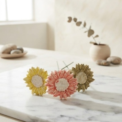 Flores decorativas de cerâmica coloridas sobre mármore branco