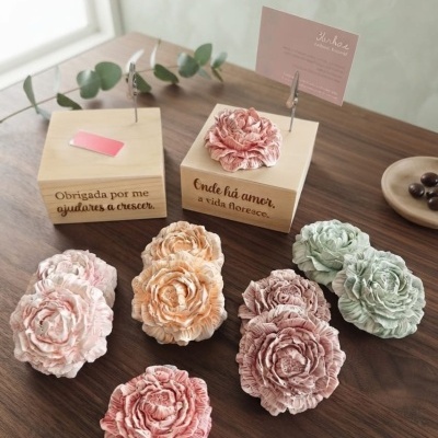Flores artificiais coloridas com caixas de madeira inscritas em mesa de madeira