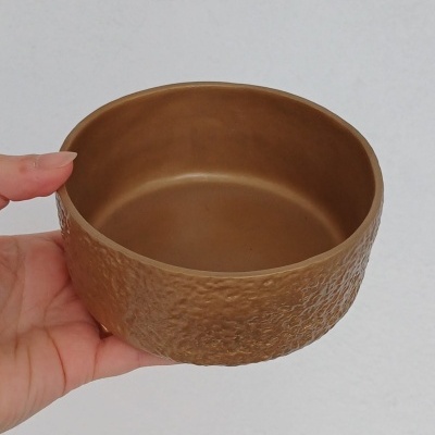 Taça de cerâmica castanho dourado com textura irregular exterior e interior liso