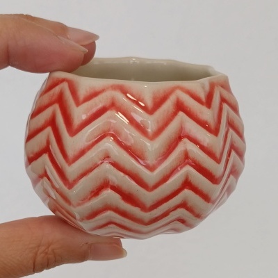 Pequeno vaso cerâmico com padrão zig-zag vermelho e branco