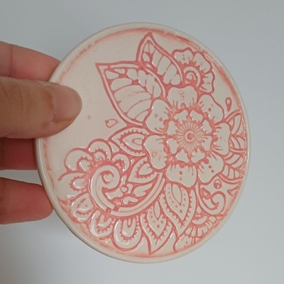 Prato redondo de cerâmica com padrão floral em relevo cor salmão
