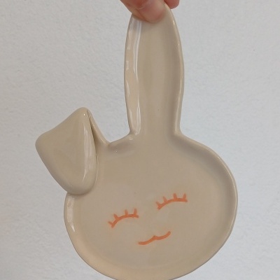 Prato de cerâmica formato cabeça de coelho bege com rosto pintado em laranja