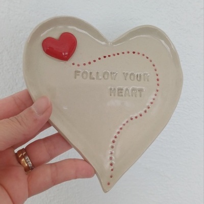 Prato de cerâmica em formato de coração com texto FOLLOW YOUR HEART e coração vermelho