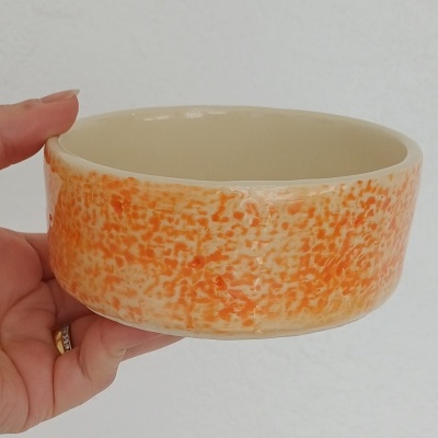 Tigela de cerâmica laranja e branca com padrão marmoreado