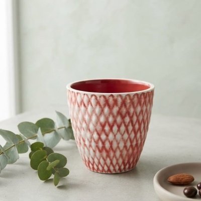 Copo cerâmico vermelho e branco com padrão geométrico