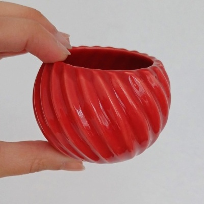 Vaso pequeno de cerâmica vermelho com padrão ondulado em relevo