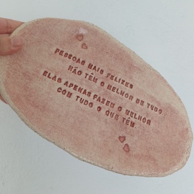 Base oval de cerâmica rosa com texto em relevo e pequenos corações