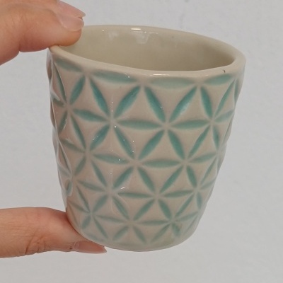 Copo pequeno em cerâmica branca com padrão geométrico verde água