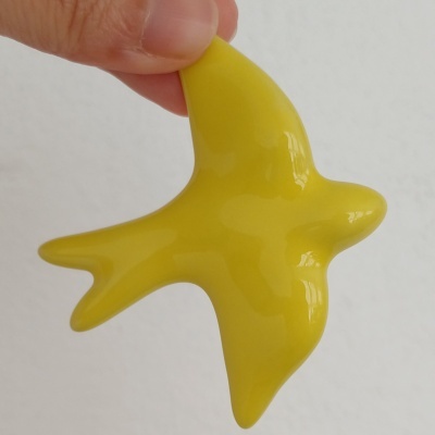 Figura decorativa amarela em forma de pássaro