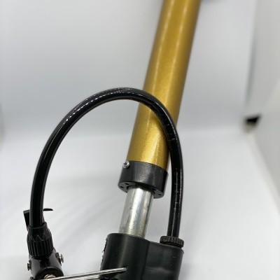 Bomba de ar portátil dourada com mangueira preta sobre fundo branco