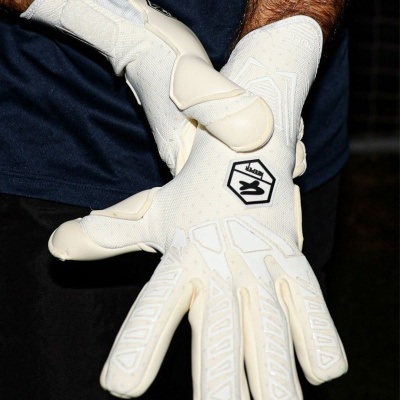 Luvas esportivas brancas com logo Keeper em uso.