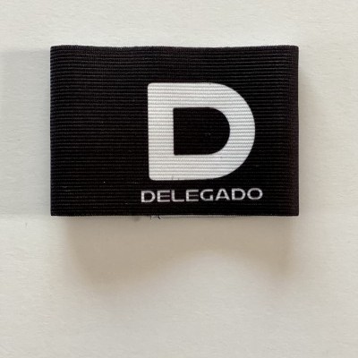 Braçadeira preta com letra D e palavra DELEGADO em branco