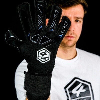 Luva desportiva preta com logo branco e azul, foco na mão, fundo preto.