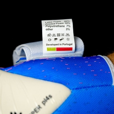 Luvas esportivas azuis com etiqueta de composição e cuidados.