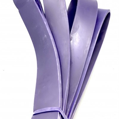 Faixa elástica de resistência roxa de borracha, dobrada e presa por elástico, sobre fundo branco